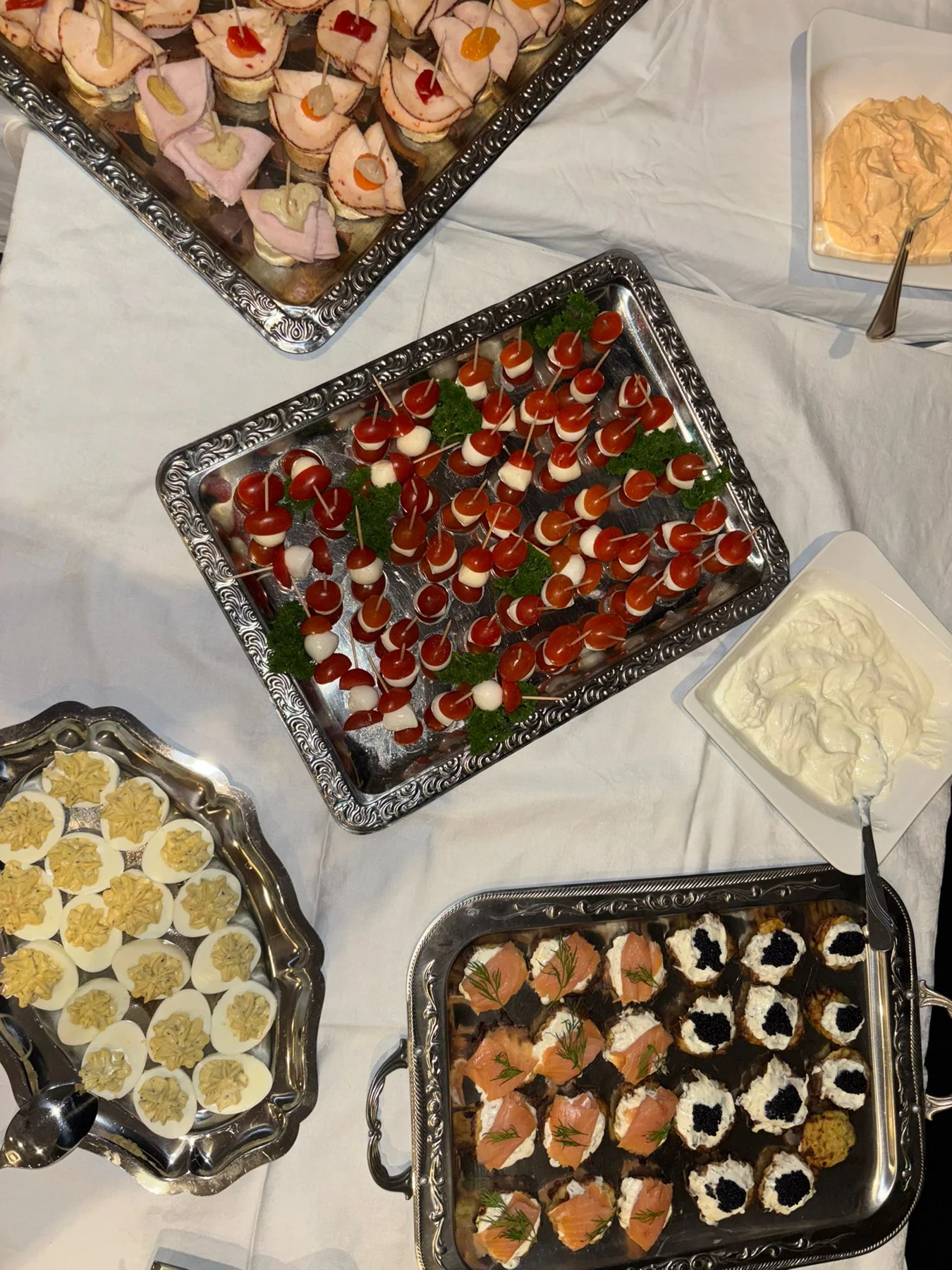 Buffet mit Tomate-Mozzarella-Spießen, gefüllten Eiern und belegten Häppchen
